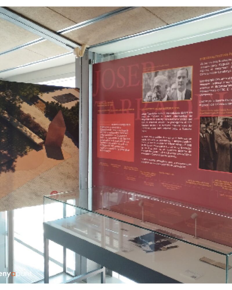 Panells d'exposició impresos en gran format instal·lats en una sala amb vitrines