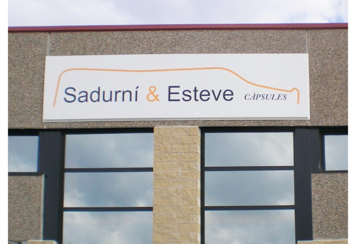 Rètol de façana de Sadurní & Esteve Càpsules acabat d'instal·lar en una nau industrial